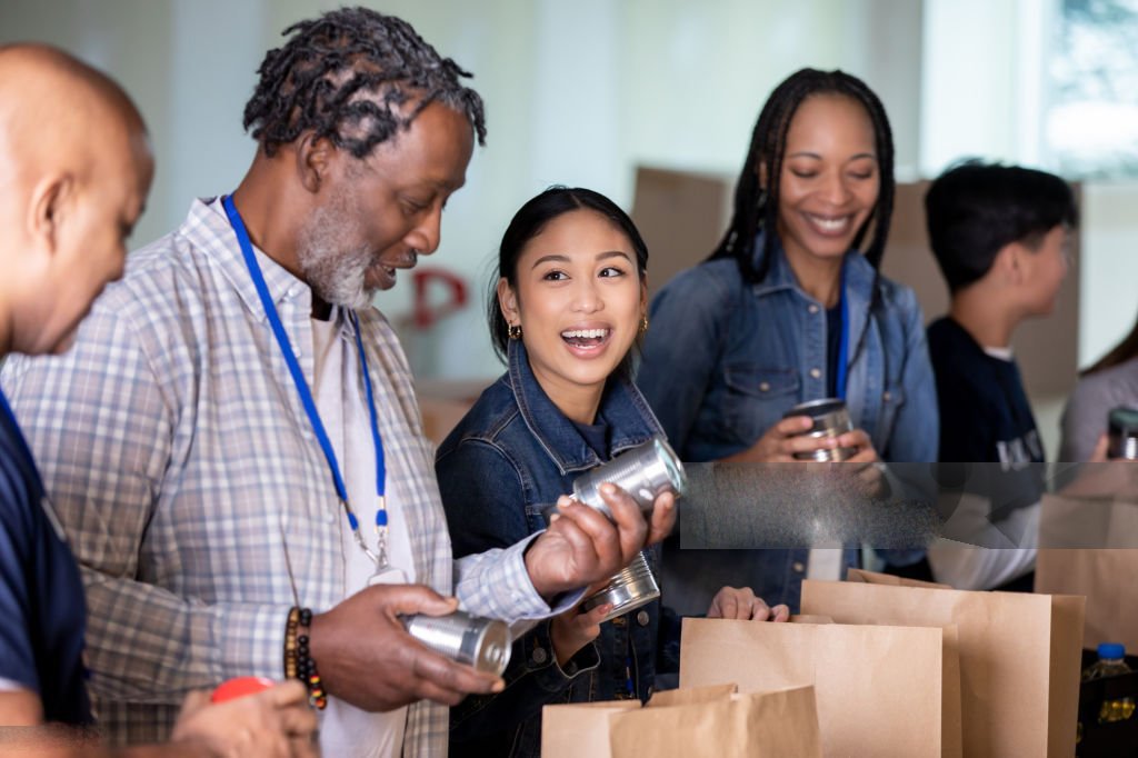 diverse group of volunteers package groceries for community at food bank